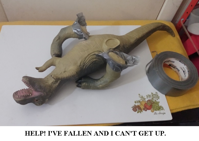 LARGE TOY MAJOR DINOSAUR WITH HIS TAPED ON LEGS FALLING OFF