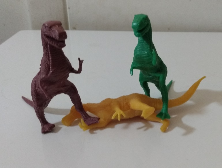 TWO TYRANNOSAURUS REXES STANDING ON TOP OF A TRACHODON